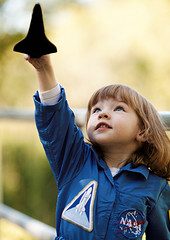 inspire dream and accomplish - image of child holding up spaceship toy